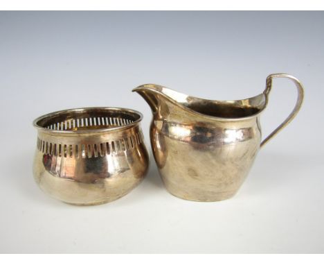 A George V silver helmet-form milk jug, together with a small reticulated silver bowl of truncated baluster form, former 6 cm