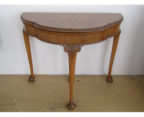 An older reproduction Georgian turn-over-top half-moon card table, the cusped top having a baize-line playing surface, on aca