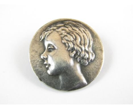 A 1920s silver circular brooch, bearing the bas-relief profile portrait of a young boy, Birmingham, 1921, 2.5 cm 