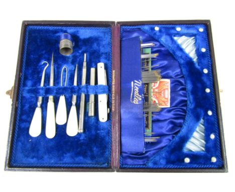 A Victorian necessaire or sewing kit, opening to reveal mother of pearl handled tools 