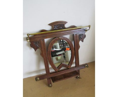 A late Victorian carved oak hall mirror and coat / hat rack, the mirror within a horseshoe shaped frame above a shelf, 66 cm 