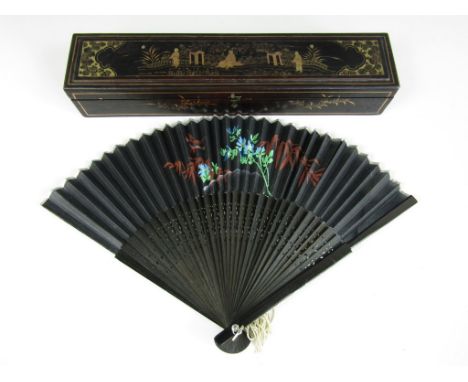 A Chinese black lacquered fan box, decorated with a gilt figural scene to the lid, and opening to reveal a florally painted s