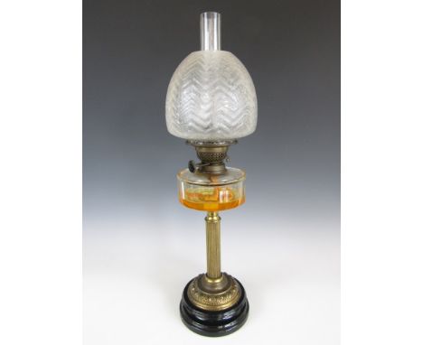 A Victorian columnar oil lamp, with funnel, etched glass globe, faceted clear glass reservoir and reeded brass column, on mou