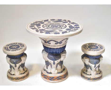 A blue and white ceramic garden table, the support modelled as an elephant, height 69cm, diameter 66.5cm, with two matching s