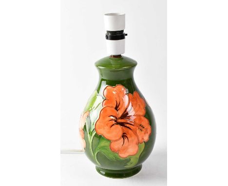 MOORCROFT; a 'Hibiscus' pattern lamp base on green ground, height including fitment 27.5cm, with impressed marks to base.Cond