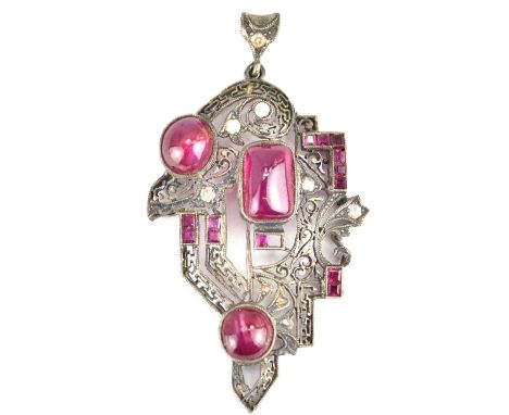 An Edwardian pendant set with an arrangement of cabochon bezel set rubies and rose cut small diamonds within openwork of flor