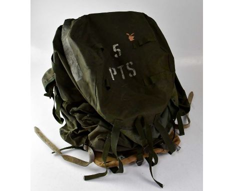 A 1970s military issue rucksack with black painted metal A-frame and white leather straps, marked to the underside of the ruc