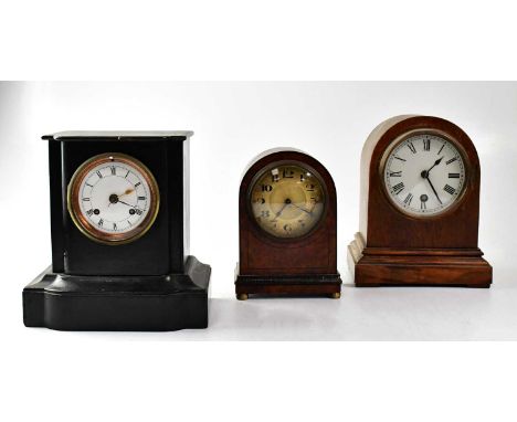 A Victorian slate-effect ebonised wooden mantel clock, together with an Edwardian oak arch-topped mantel clock and a walnut-e