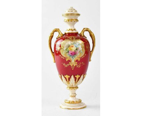 ROYAL WORCESTER; a twin-handled waisted vase with red ground and painted cartouche of roses, gilt highlighting, raised on a c