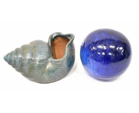 A large ceramic model of a shell in green glaze, 23 x 42cm, and a ceramic ball in dark blue mottled glaze, height 30cm (2).Co