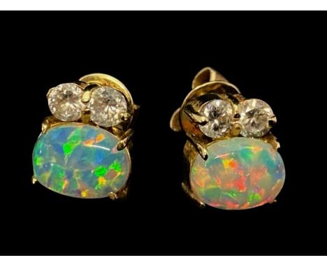 A pair of quality white opal cabochon flashing blue, violet &amp; red and green, earrings set in 14ct gold. With intergrated 