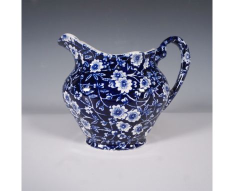 A Burleigh Calico creamer featuring an intricate blue and white floral pattern. Crafted in Staffordshire, England, this ceram
