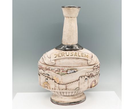A vintage handcrafted ceramic vessel featuring a raised relief depiction of Jerusalem's historic skyline. The bottle is adorn