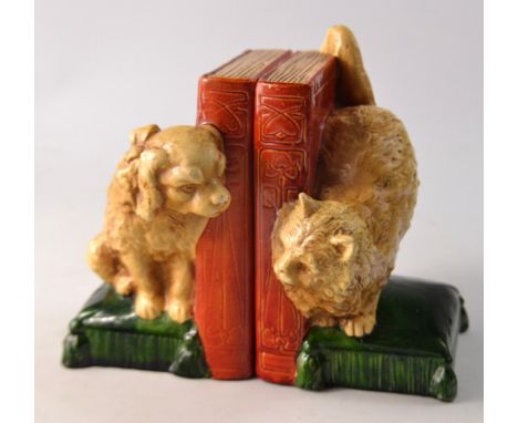 FABULOUS c1920s- 30s pair of bookends by Bretby featuring a cat and dog sat on cushions peering around a book at each other. 