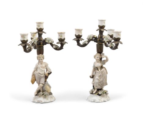 A PAIR OF 19TH CENTURY GERMAN PORCELAIN FIGURAL CANDELABRA,with four light, three branch detachable sconces, supported by a m