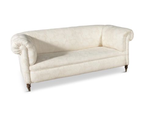 A VICTORIAN MAHOGANY FRAMED CHESTERFIELD COUCH,covered in a cream floral damask, with out scrolling arms and back, stuffed se