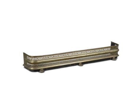 A VICTORIAN PIERCED BRASS CURB FENDER,raised on paw feet. 152cm wide
