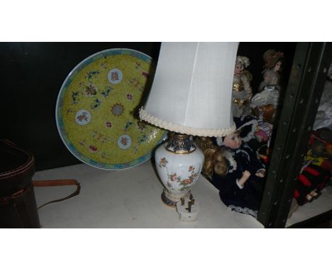 A large Chinese plate and a table lamp