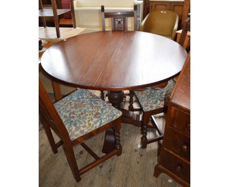 A circular dining table and three chairs, a small stool and a small hanging shelf