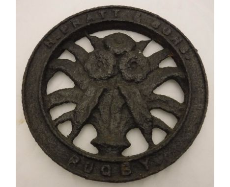 An H. Pratt & Sons Rugby cast iron wheel hub, the centre with decoration of flowers in a vase, assorted further iron and copp