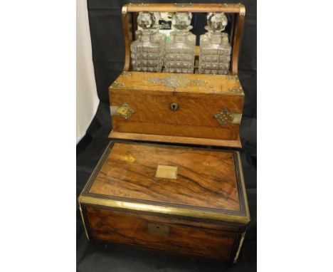 A Victorian oak and brass bound tantalus with three hobnail decanters and twin-lidded compartment opening to reveal four tot 