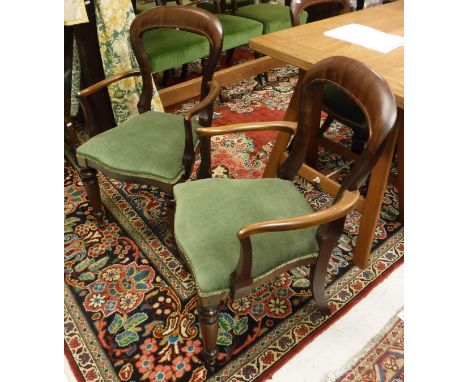 A set of ten Victorian style mahogany balloon back dining chairs to include two carvers with green seats and serpentine front