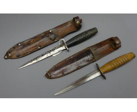 Two wooden handled Commando Knives, 16cm twin edged steel blade with brass cross guard, bold ribbed grip with sunken top reta