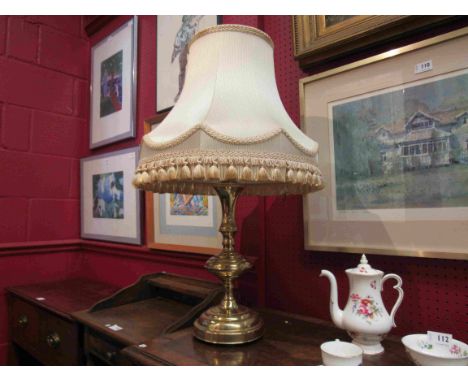 A brass table lamp with tasselled shade
