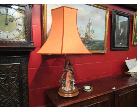 A figural table lamp, robed lady holding fruit, on stand with shade 