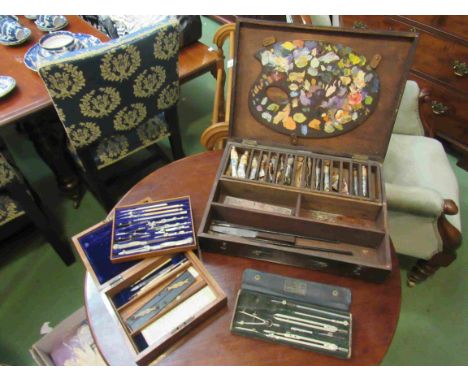 A rosewood artists/painters box containing a palette and used oil paints and architects drawing tools