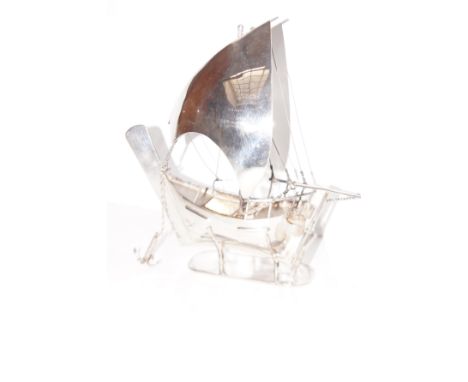 Sterling silver model of a sailing boat on a silver stine, height 23 cm and length 23 cm  