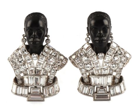 A matching pair of Art Deco ebony and diamond 'Moretto' brooch clips, each depicting a carved ebony head, with collet set dia