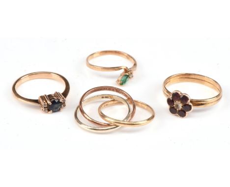 Four rings, including a Russian wedding band stamped 9 ct, size G, a marquise cut emerald and diamond set ring, stamped 9 ct,