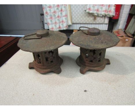 A pair of cast iron Pagoda form tea light holders, approximately 12cm high 