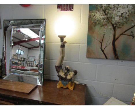 A modern Art Deco style electric table lamp base as an exotic dancer lying on her back, balancing a spherical glass shade on 