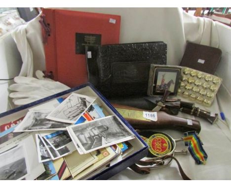 A collection of military militaria including 2 albums of WW2 photographs, set of buttons, postcards, stirrups, sash, rifle bu