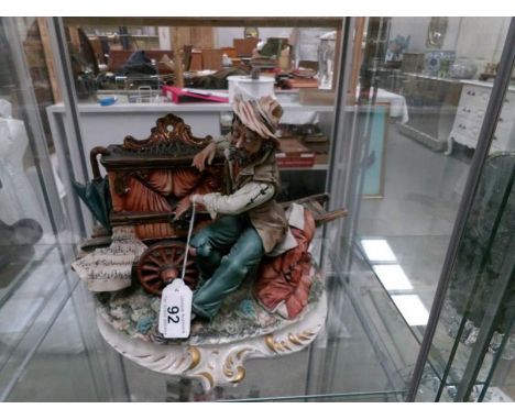 A Capo-di-Monte figure of an organ grinder.