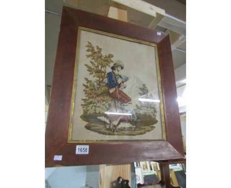 A framed Victorian wool work depicting a gentleman hunter / poacher smoking a pipe.