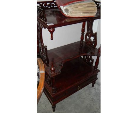 A mahogany shelf unit with drawer.