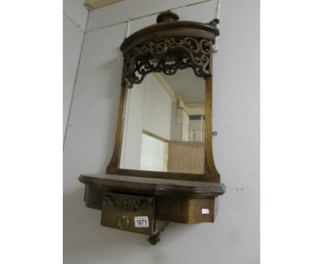 A wall mirror with shelf and drawer.