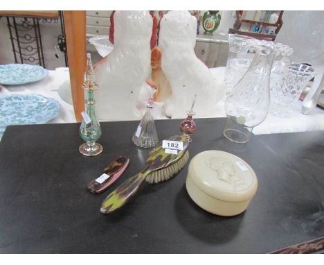 An old celluloid powder pot, a tortoise shell case comb, hairbrush and 3 scent bottles.