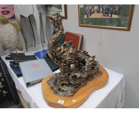 An interesting hand formed ceramic dragon, gold painted on rock detail and on wooden base (a/f)