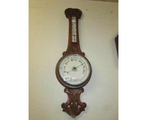 An Edwardian oak barometer with porcelain dial.