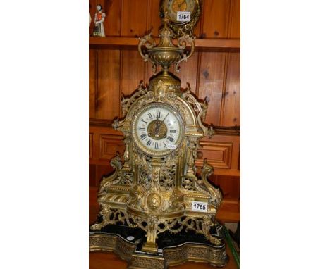 A large ornate brass mantel clock.