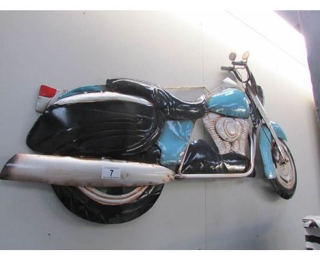 A metal motor cycle wall plaque.