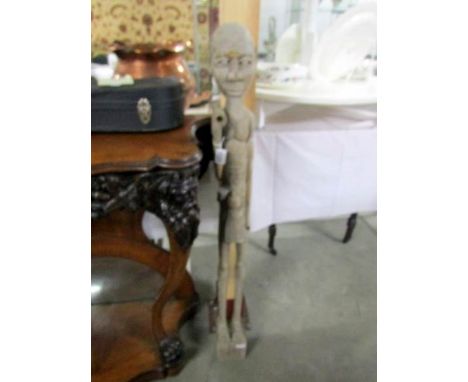 An early 20th century tribal art tall carved figure (possibly Madascan) of a man holding an item (missing)