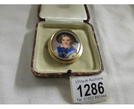 A German hand painted miniature portrait of a girl in gold mount.