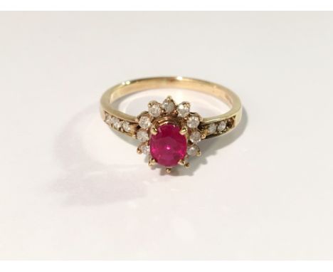 A ruby and diamond oval cluster ring within a surround of circular cut diamonds in 9ct gold, approximate size J Half.