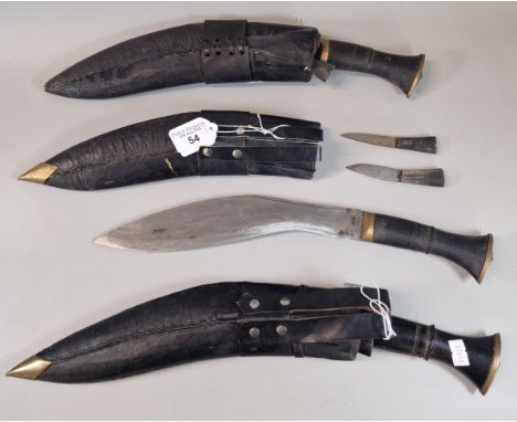 Three Nepalese Kukri, with hardwood grips, leather scabbards and miniature knives included. (3) (B.P. 21% + VAT). NO IN HOUSE