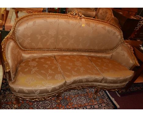 A Louis XV style giltwood sofa, with golden silk upholstery, raised on cabriole legs